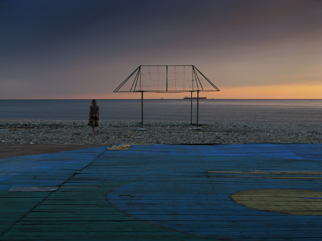 Одинокая девушка стоит на берегу моря - обои на телефон