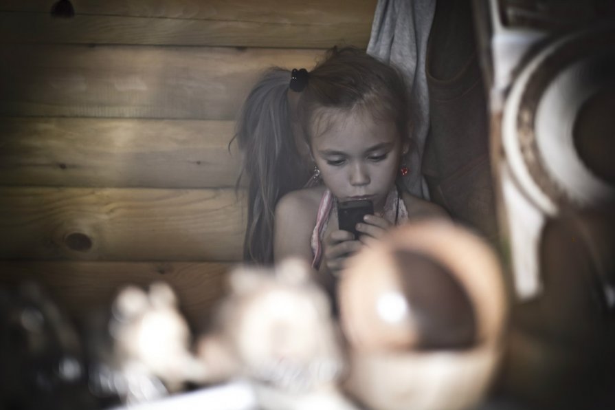 девочка в сувенирной лавке,увлеченная телефоном - Артем Otlyakov