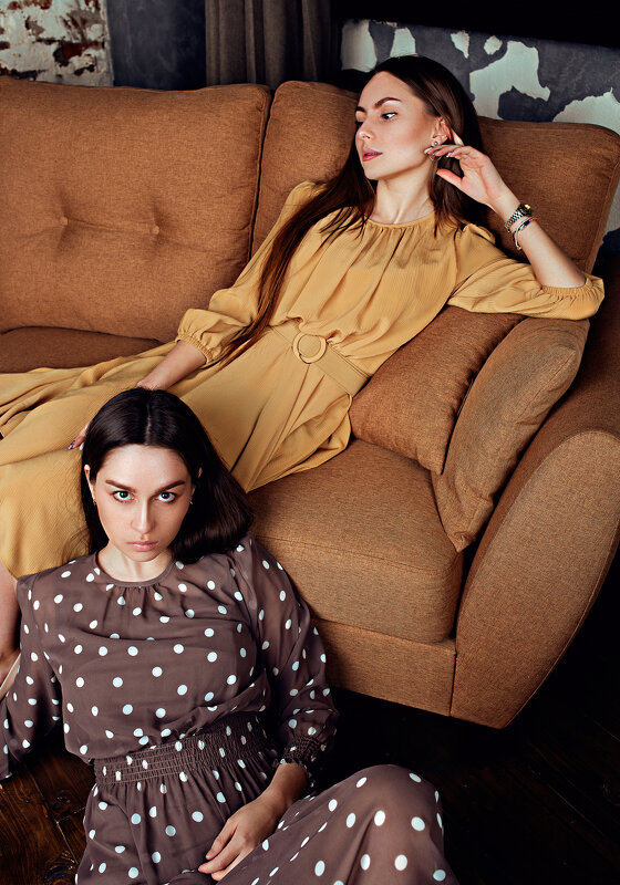 Две девушки в платьях в стариной студии на оранжевом диване - Lenar Abdrakhmanov