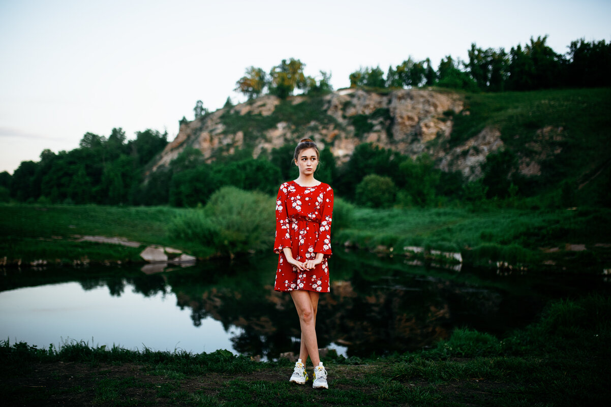 Девушка в красном платье и кедах стоит на берегу голубого озера на фоне горы во время рассвета - Lenar Abdrakhmanov