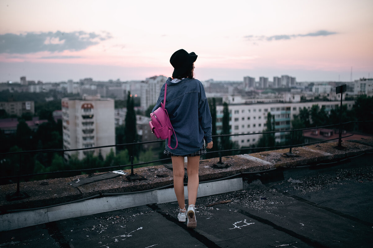 Девушка в шляпе белой рубашке и джинсовой куртке на крыше во время заката с розовым портфелем - Lenar Abdrakhmanov