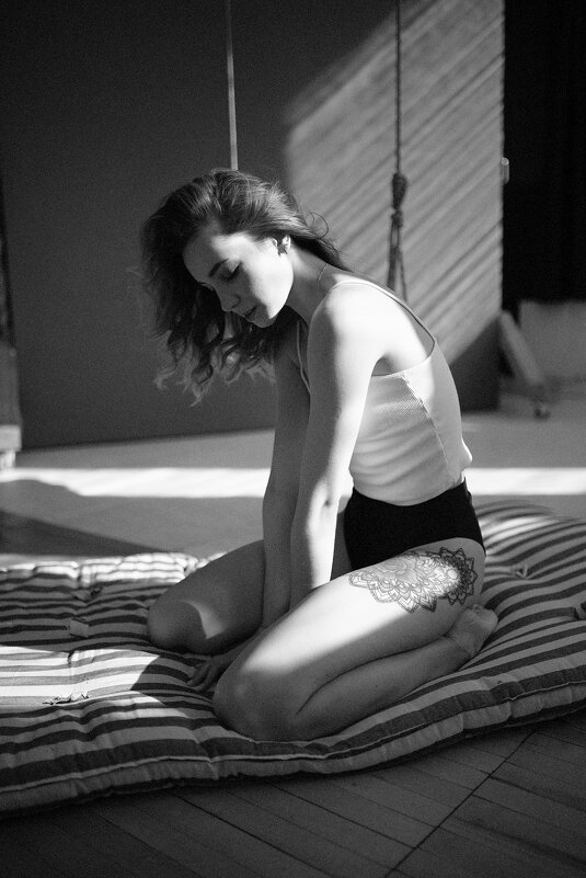 Девушка в белом топе и черном белье сидит на полосатом матраце под солнечными лучами - Lenar Abdrakhmanov