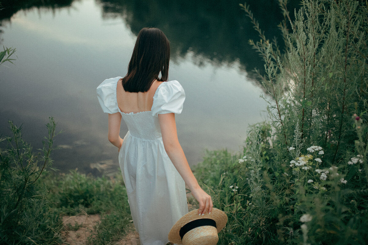 Девушка в белом платье со шляпой в руках спускается по тропинке к речке - Lenar Abdrakhmanov