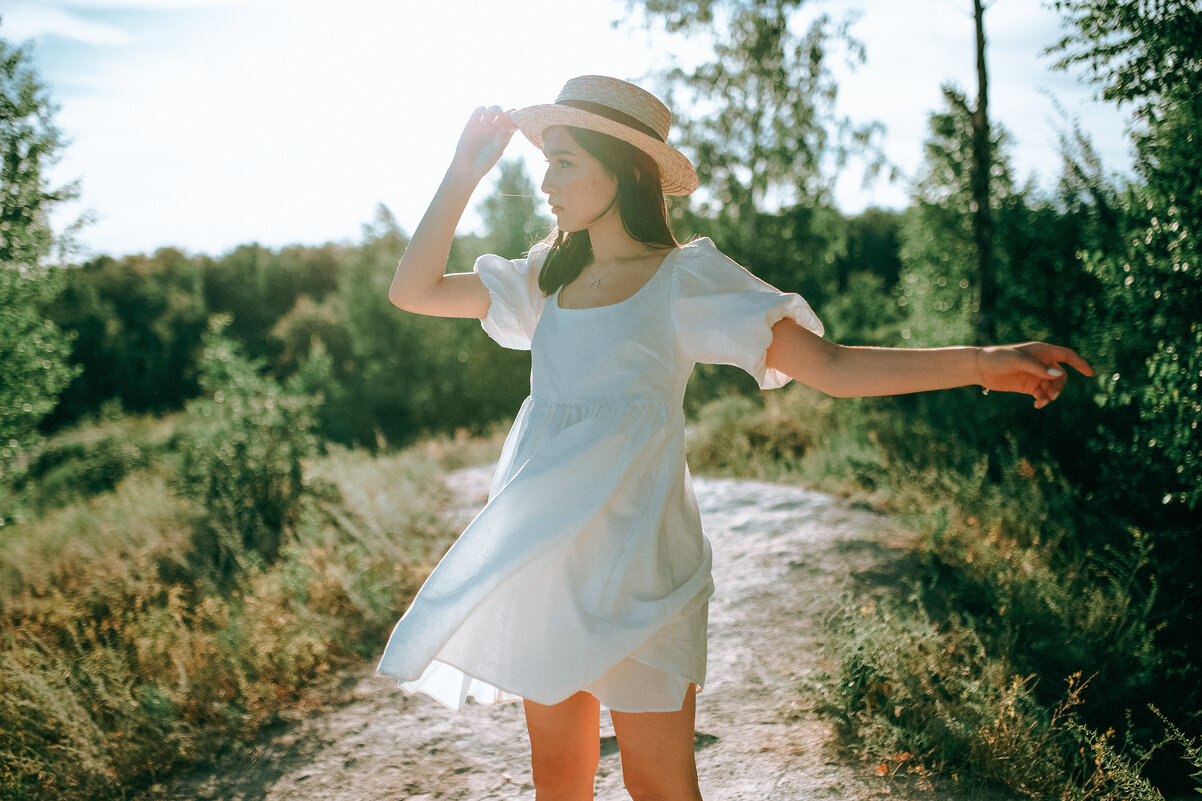 Девушка в белом платье со шляпой у руках гуляет по лесной поляне - Lenar Abdrakhmanov