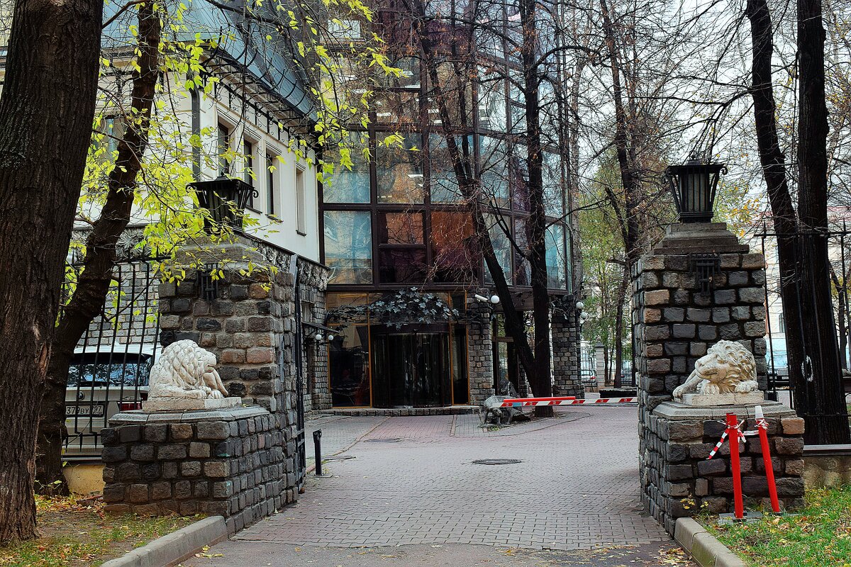 Проход во двор охраняют ворота с колоннами на которых лежат два скульптурных льва - Татьяна Помогалова