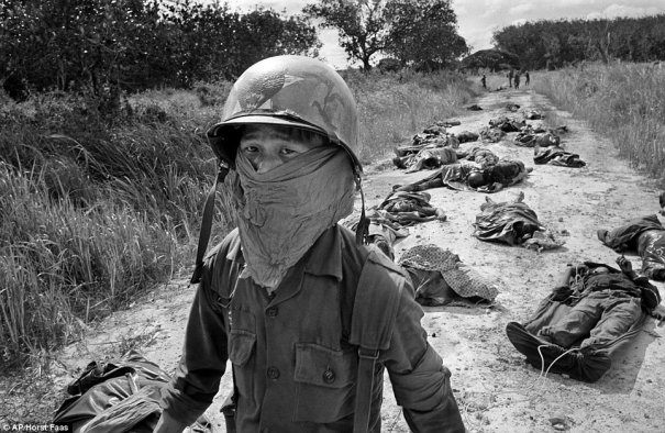 Вьетнамский санитар обходит тела американцев и солдат южно-вьетнамской армии, убитых в боевых действиях против Вьетконга в 45 милях к северо-востоку от Сайгона, в ноябре 1965 года