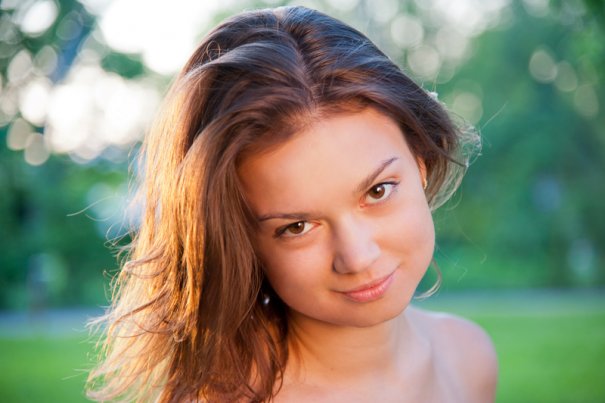 Portrait of beautiful woman at the sunset in the park