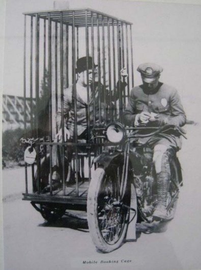Полицейский, мотоцикл Harley-Davidson, и заключенный в клетке. 1921 год.