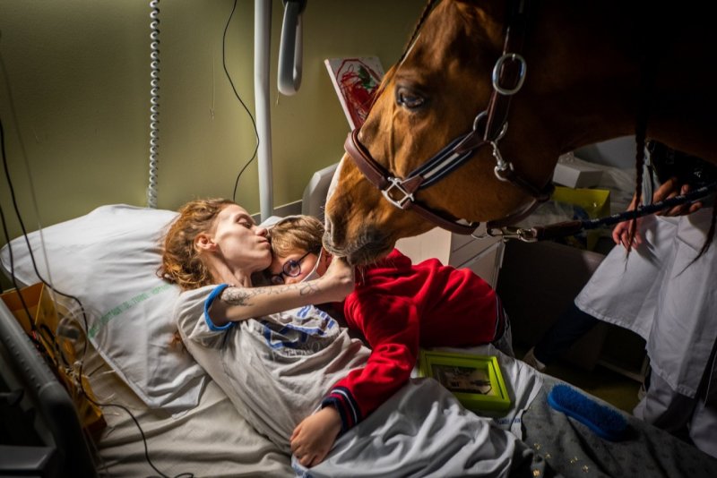 2 место в категории «Современные проблемы», 2021. Марион с метастатическим раком обнимает своего сына в присутствии лошади, используемой в терапии в отделении паллиативной помощи. Кале, Франция, 30 ноября 2020 года. Автор Джереми Лемпин.
